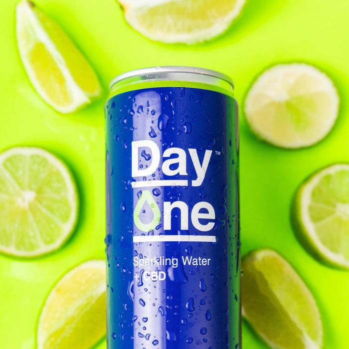 A can of Day One CBD sparkling water with scattered lime slices