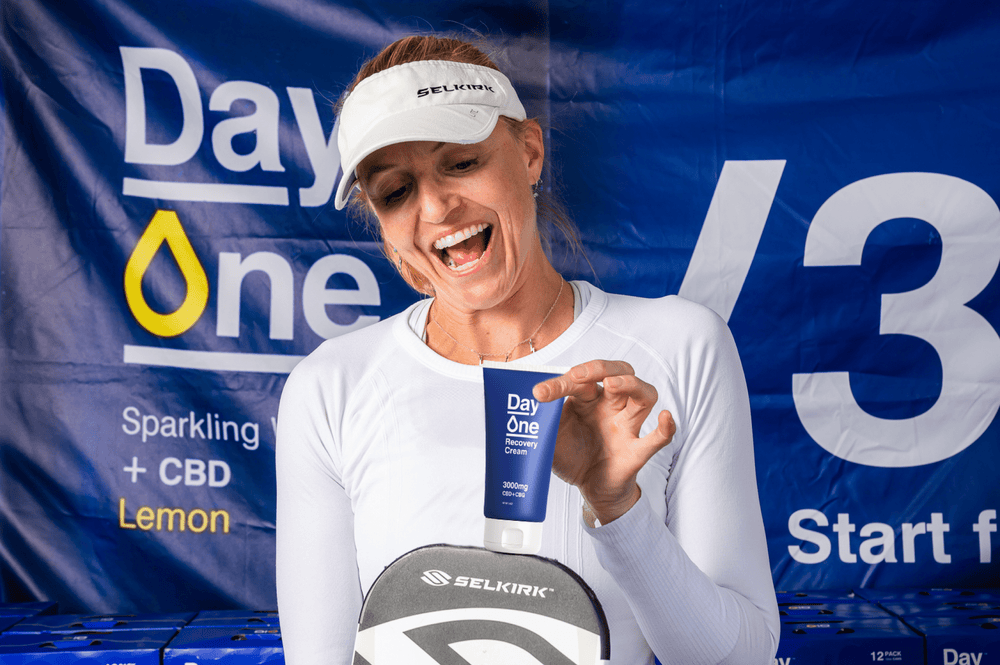 
                  
                    A women at a pickleball event holding a tube of CBD cream 
                  
                